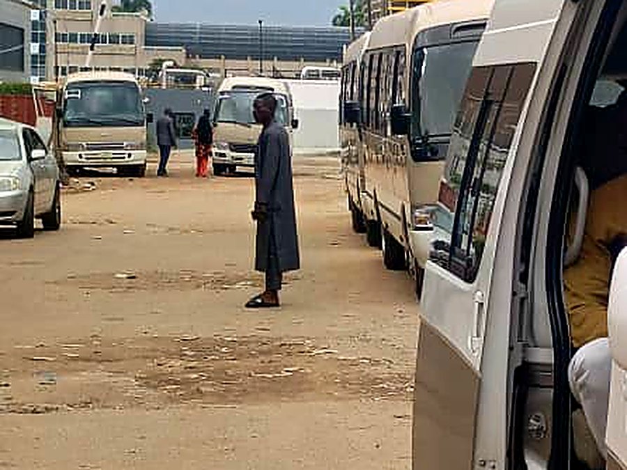 Coaster buses queued along a corporate corridor in central Abuja